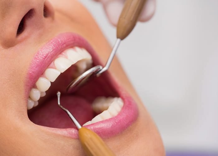 dentista-examinando-dientes-paciente-femenino (1)